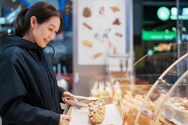 istock Woman Selecting Fresh Pastries in Cozy Bakery Setting 2208228159