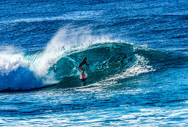 Colorful Surfer Green Room Large Wave Banzai Pipeline Pipeline North Shore Oahu Hawaii. Huge Waves Over Shallow Reef create tubes, large hollow curls of water that surfers can ride. The shallow reef creates a dangerous beautiful place to surf.