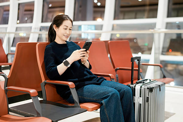 istock Relaxed Traveler Using Smartphone While Waiting at Airport Lounge 2208233369