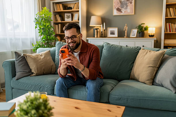 istock Happy young man using smart phone at home. 2208233687