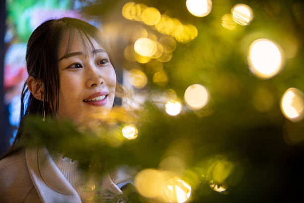 Woman looking at Christmas tree in city