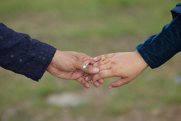istock Couple holding hands, blurred summer landscape in the background 2208237089