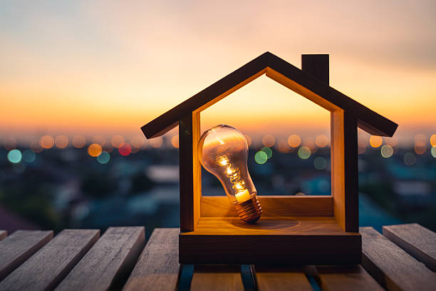 istock Light bulb with wood house on the table, a symbol for construction, Creative light bulb idea, power energy or business idea concept ecology, loan, mortgage, property or home. 2208248492