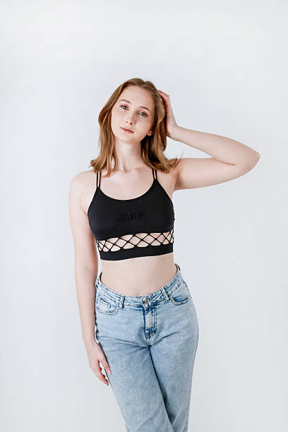 istock A woman in jeans and a black top on a light background. 2208251834