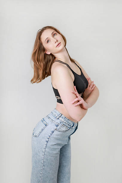 istock A woman in jeans and a black top on a white background. 2208252044
