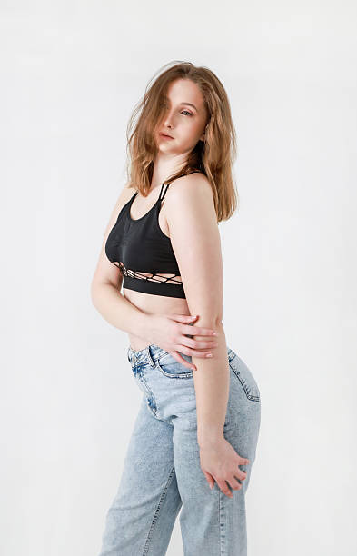 istock A woman in jeans and a black top on a white background. 2208252320