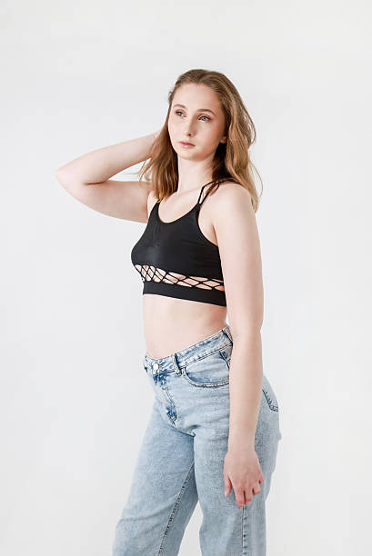 istock A woman in jeans and a black top on a white background. 2208252407
