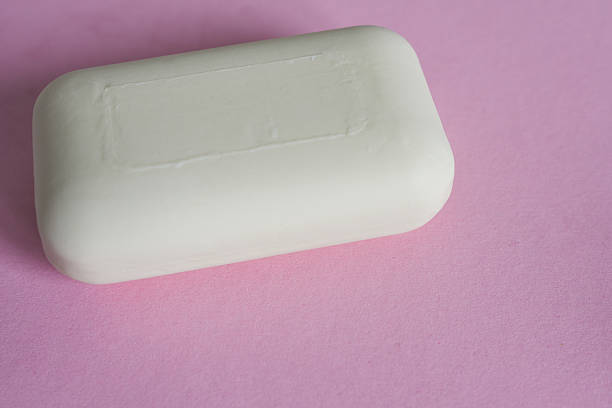 White soap bar on pink background. Top view with copy space.