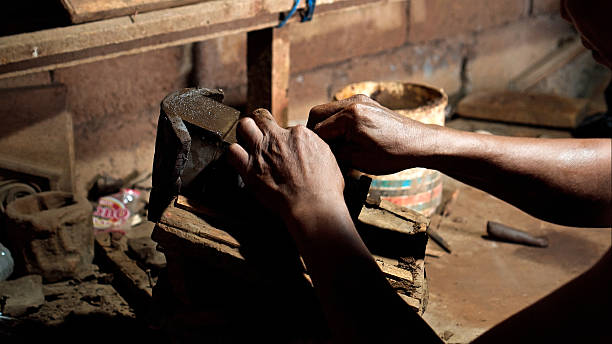 istock Dirty hands of worker making clay statue in Balinese style in dark workshop 2208256547