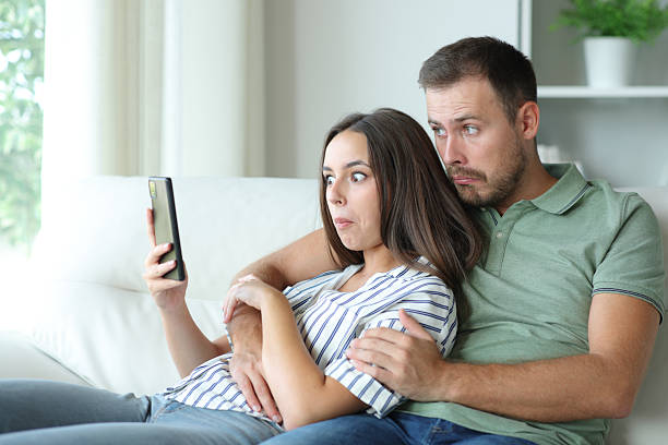 istock Perplexed couple at home checking mobile phone 2208261250