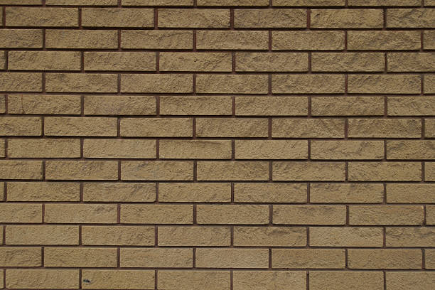 istock Dusty surface of beige split face brick veneer wall with running bond layout 2208261859