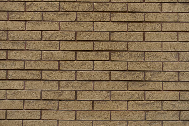 istock Texture of beige split face brick veneer wall with running bond layout 2208261885
