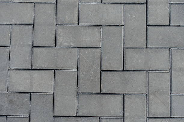 istock Close shot of grey concrete pavement with single herringbone layout 2208261928