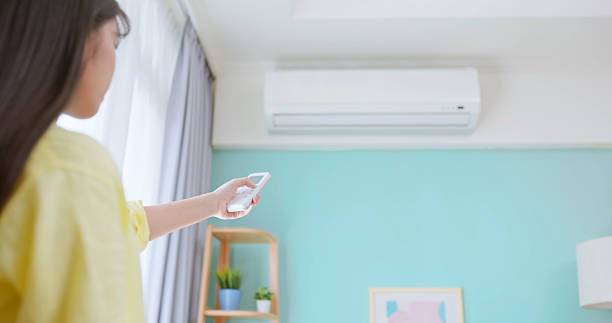 istock woman turn on air conditioner 2208263439