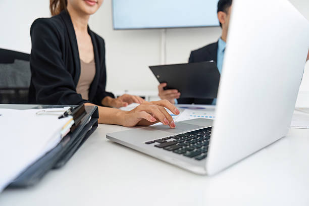 istock Data Analysis and Digital Presentation. A team member engaged in a discussion with colleagues over a laptop. 2208265906
