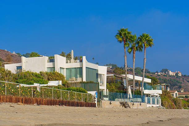 Malibu, California - December 21, 2024: Malibu's coastline with breathtaking beachfront houses nestled among palm trees and sandy shores.