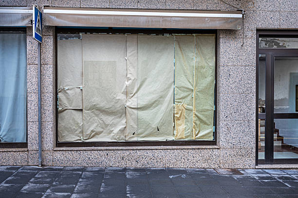 istock Bankrupt shop with windows covered with brown paper 2208268553