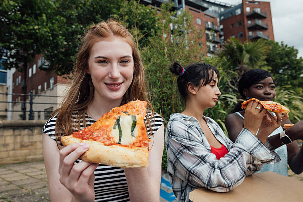 istock Girls Enjoying Pizza Together 2208269980