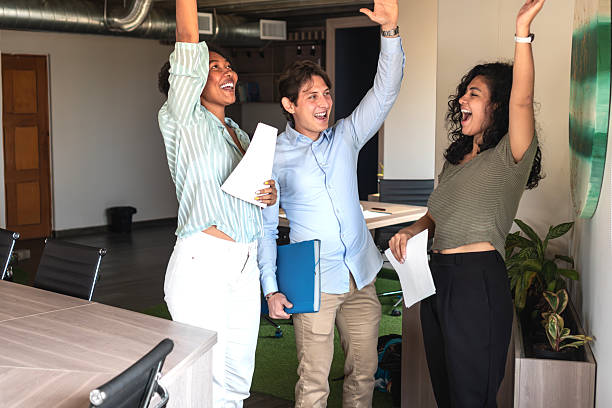 Excited business team celebrating success in modern office