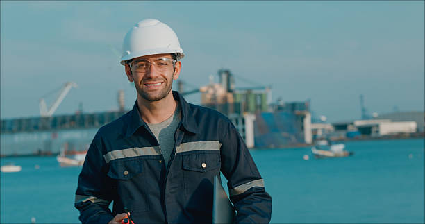 istock Portrait maintenance engineer smiling handhold computer notebook after meeting plan to repair or rebuild a large bulk ship damaged at a Commercial Shipyard. 2208274515