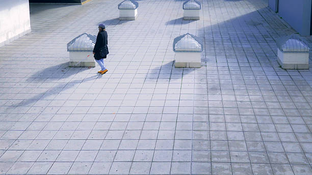 istock Blind person navigating a tiled walkway with obstacles, demonstrating independent mobility and urban accessibility 2208274761