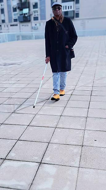 istock Confident visually impaired mature adult navigating urban environment with white cane, showcasing independent mobility and inclusion 2208275589