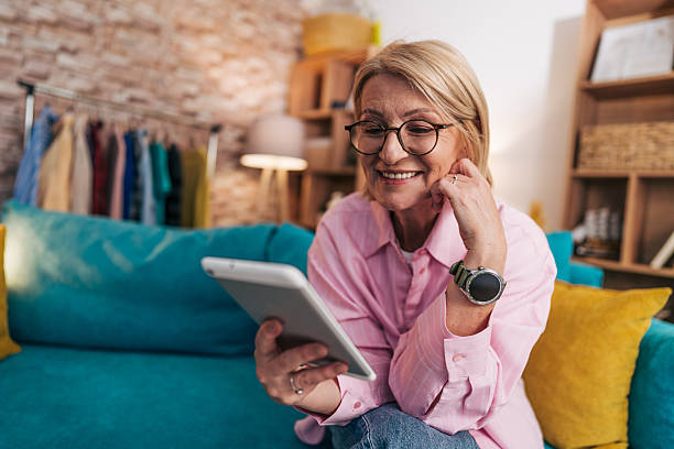 istock Smiling senior woman using digital tablet at home 2208277397