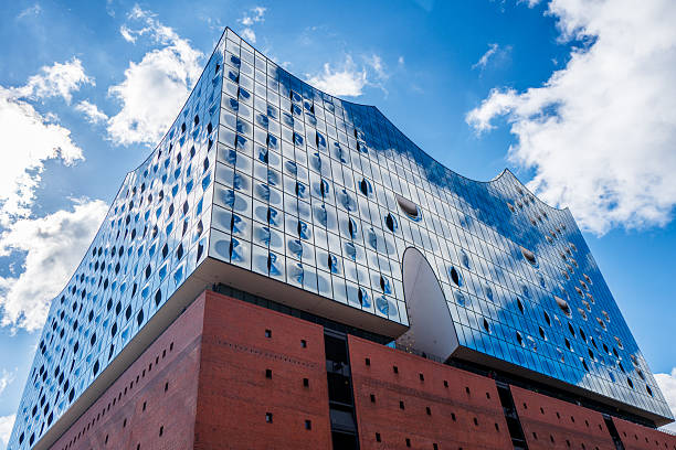 Hamburg, Germany. March 31st, 2025: A striking view of the Elbphilharmonie Concert Hall, one of Hamburg's most iconic landmarks. The modern architectural masterpiece, located in the HafenCity district, features a glass structure that resembles a wave, sitting atop a former warehouse. The concert hall has become a symbol of innovation, offering breathtaking views of the harbor and the city.