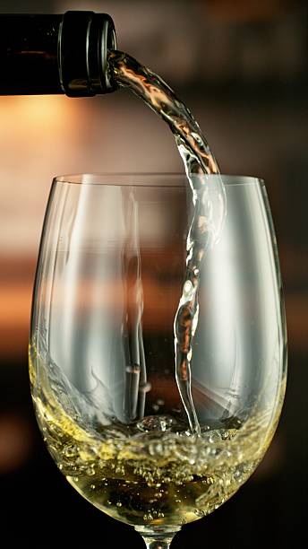 istock Detail of pouring white wine from bottle. 2208281475