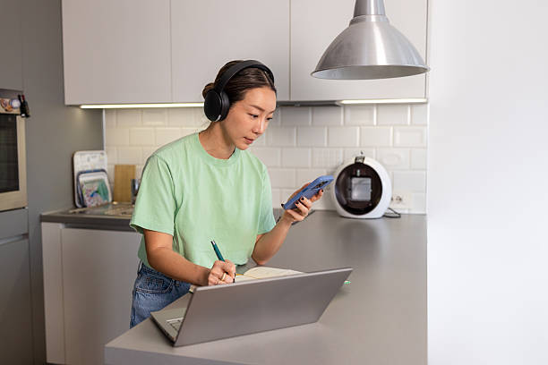 istock Asian woman working at the kitchen counter at home 2208282462