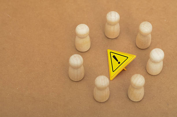 istock Caution Symbol Amidst a Group of Wooden Figures  Risk and Awareness Concept 2208282843