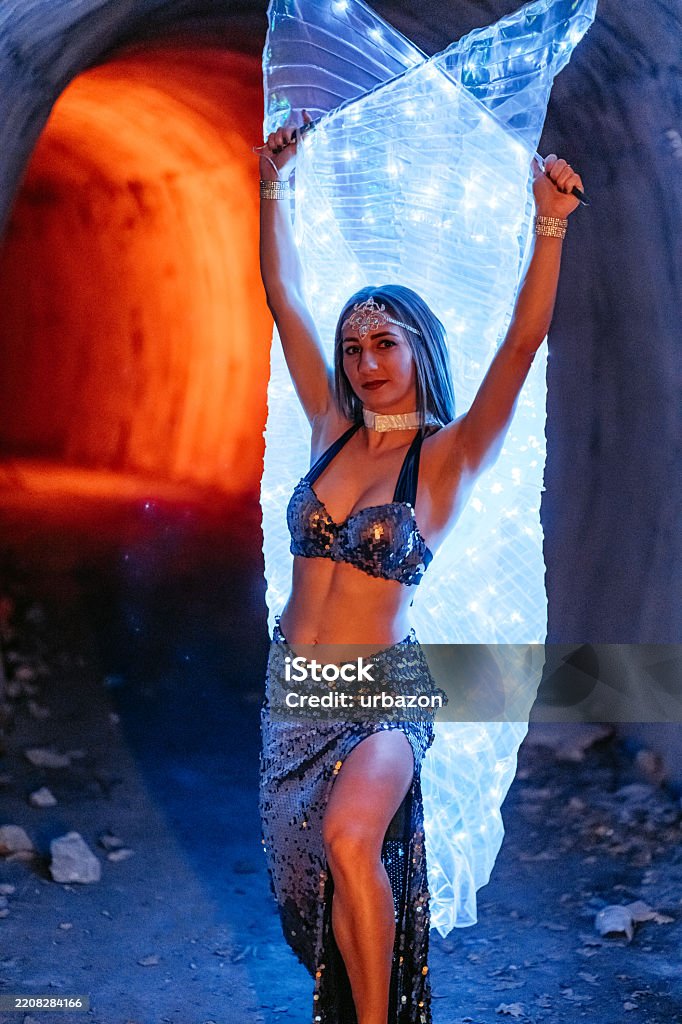 Tânără Femeie Într-Un Costum Strălucitor Executând Dansul Din Buric Pe O Scenă Sub Un Reflector - Fotografie de stoc Gesticulare fără redevențe Tânără Femeie Într-Un Costum Strălucitor Executând Dansul Din Buric Pe O Scenă Sub Un Reflector - Fotografie de stoc Gesticulare fără redevențe