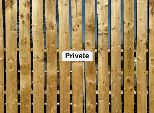 Black and white private sign on a wood panelled fence