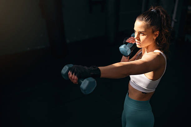istock Female kickboxer shadowboxing with dumbbells 2208288799
