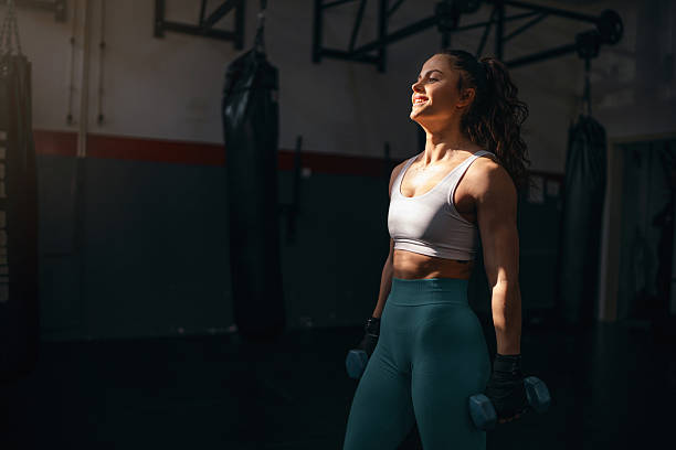 istock Young woman working out with dumbbells 2208288842