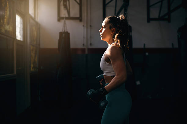Young woman working out with dumbbells