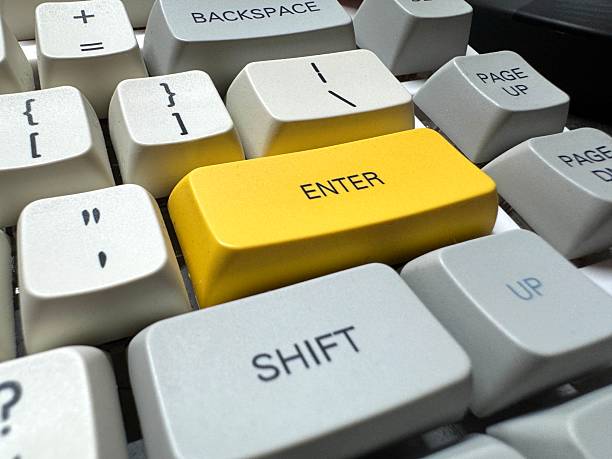 istock Large yellow Enter button in English on mechanical white keyboard for programmers with gray shades and red switches left side view 2208289863