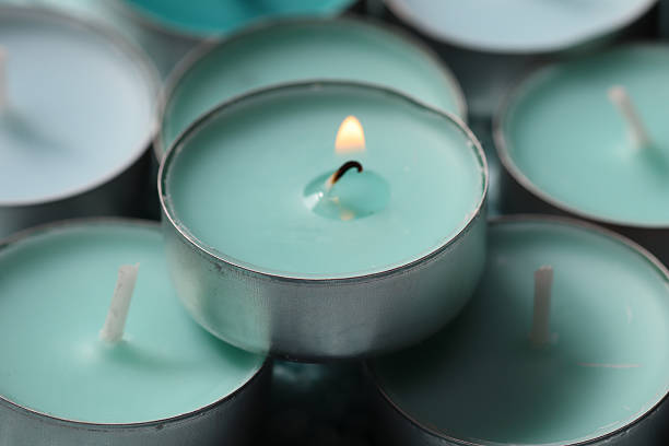 istock Burning tealight candle among unlit ones in soft mint tones 2208290942