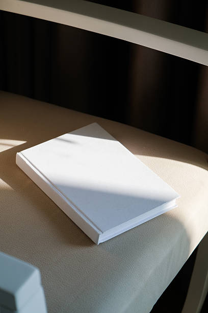 istock blank book mockup on soft armchair , shadow overlay 2208292123
