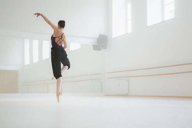 istock Young Ballet Dancer Performing Graceful Leap In Sunlit White Studio With Ethereal Atmosphere 2208292423