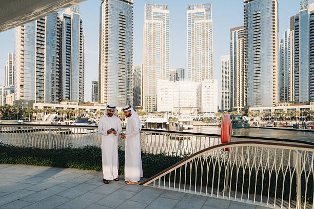 istock Arab businessmen using smartphones in Dubai Marina 2208295139