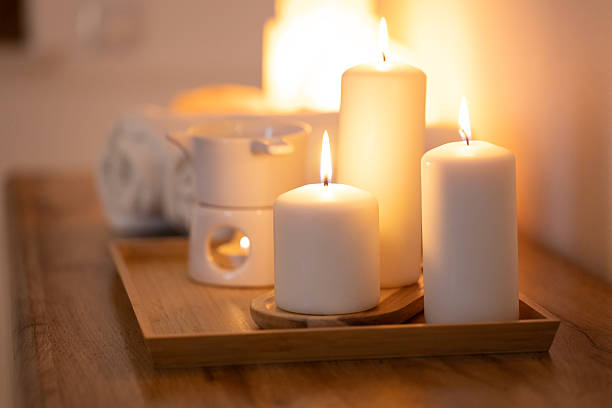 Atmospheric, burning candles and an essential oil warmer, creating a warm, relaxing home spa ambiance.