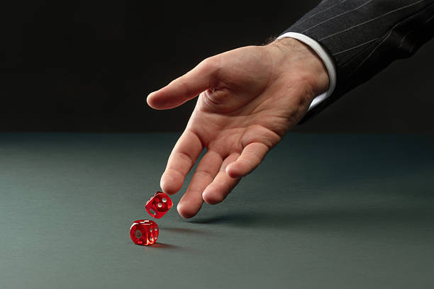 istock Male hand rolls red dices on green table 2208295647
