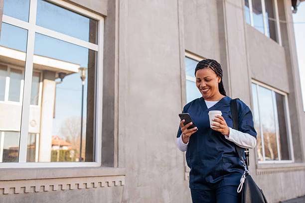 istock Nurse using her phone outdoors 2208296720