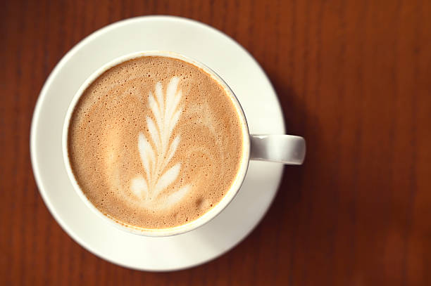 istock Coffee Latte with milk foam on brown table at cafe 2208301619