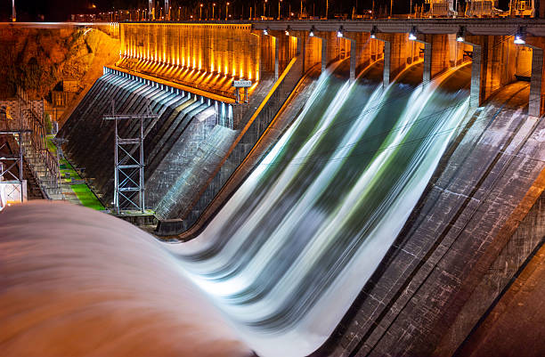 Night panoramic view on water discharge on hydroelectric power station at Divnogorsk in Krasnoyarsk, Russia. Industrial landscape with Krasnoyarsk Dam at sunny day. Powerful water flow. Blurred motion