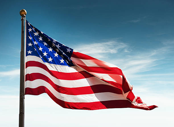 american flag against the sky at dusk