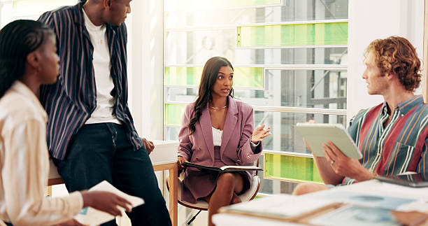 istock College, students and talking for education in class for group study, help and prepare for presentation. People, planning and discussion with learning advice, sharing knowledge and university course 2208314603