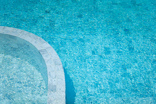 Luxury style swimming pool building with white marble floor and brightness blue water. Close-up and selective focus.