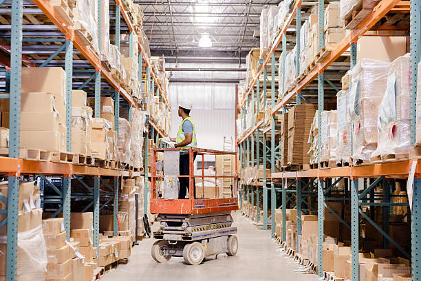 istock Warehouse Worker Using Scissor Lift to Stock Shelves 2208318615
